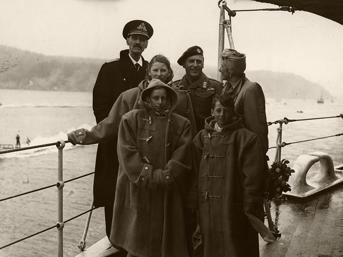 HSE Norfolk in the Oslo fjord, returning home to a free Norway. It was a cold, cloudy day, and the children borrowed warm clothes from the crew. Photo: Royal Navy/The Royal Collections.